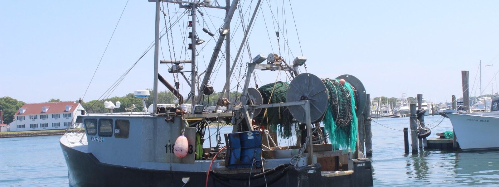 Fishing trawler pulling out from a dock.
