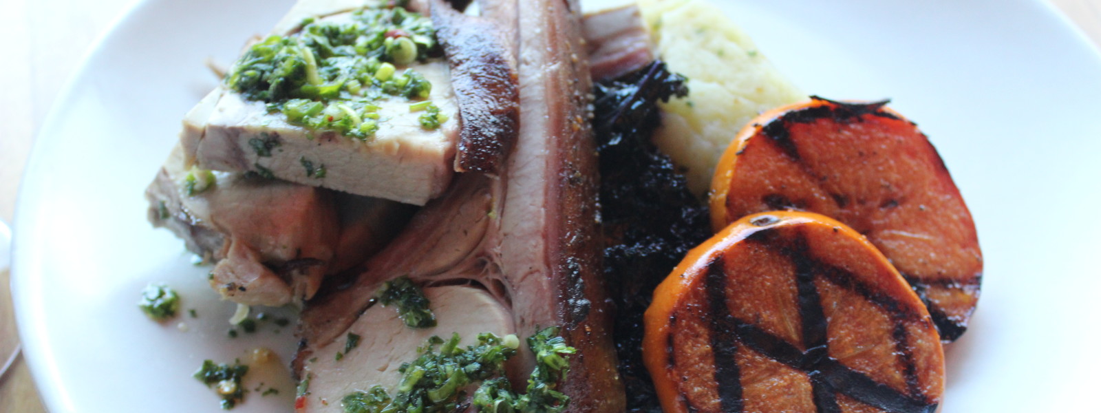 Pork chop with sweet potatoes and chimichurri.