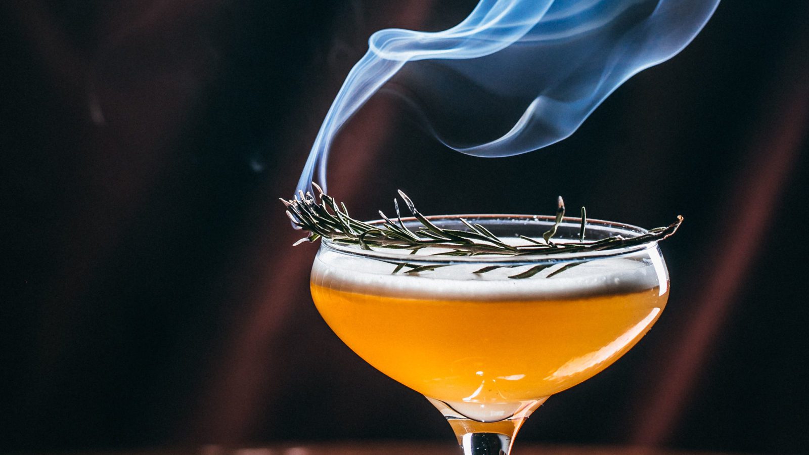 Cocktail in coupe glass with smoke rising from top.