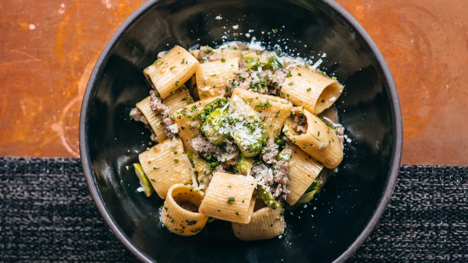 Rigatoni dish with fresh grated cheese and chives.